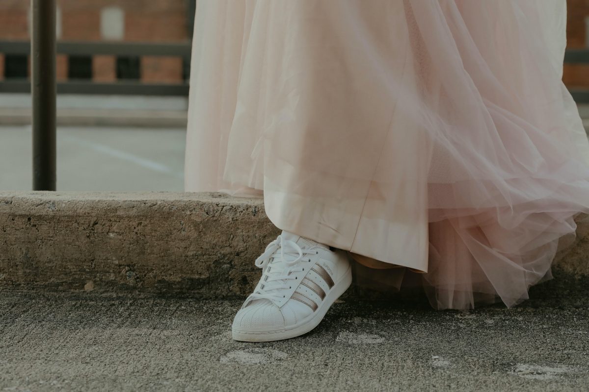 woman wearing a wedding dress with sneakers.